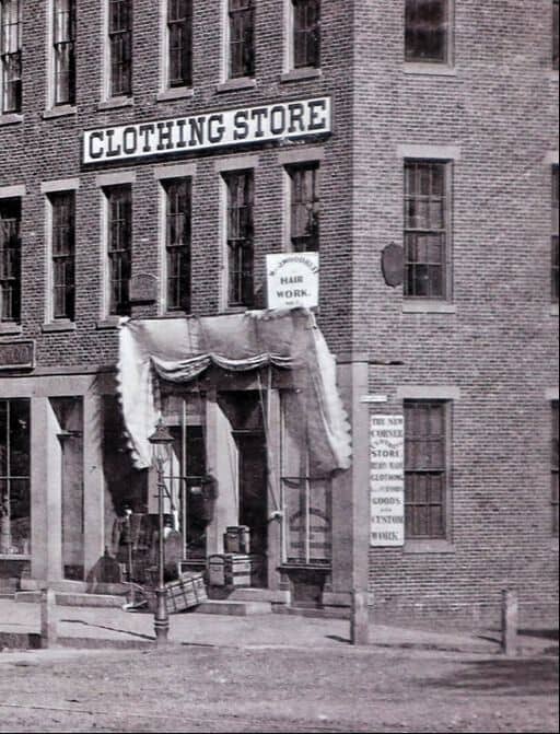 photo of the corner of a brick building with a large sign reading 'Clothing and a smaller sign below. Store'