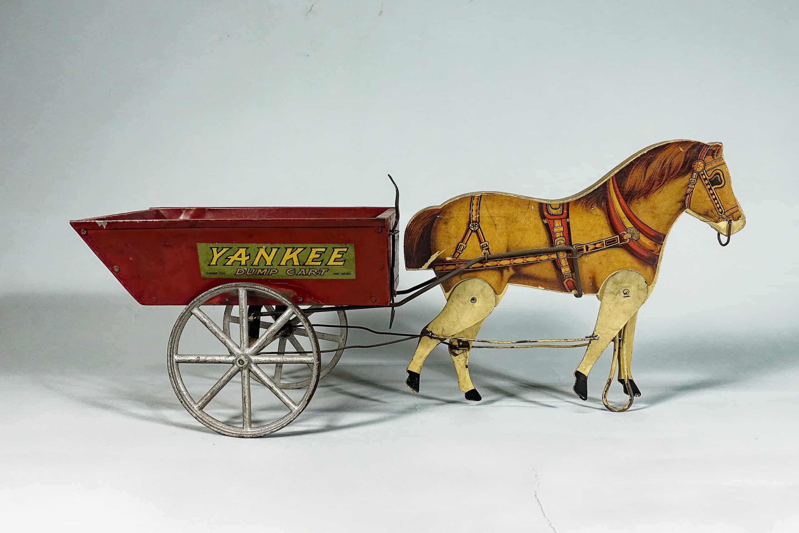Photograph of a horse and red carriage toy. The carriage reads: "YANKEE / DUMP CART."