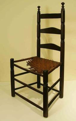 Wooden ladderback chair with torn straw seat