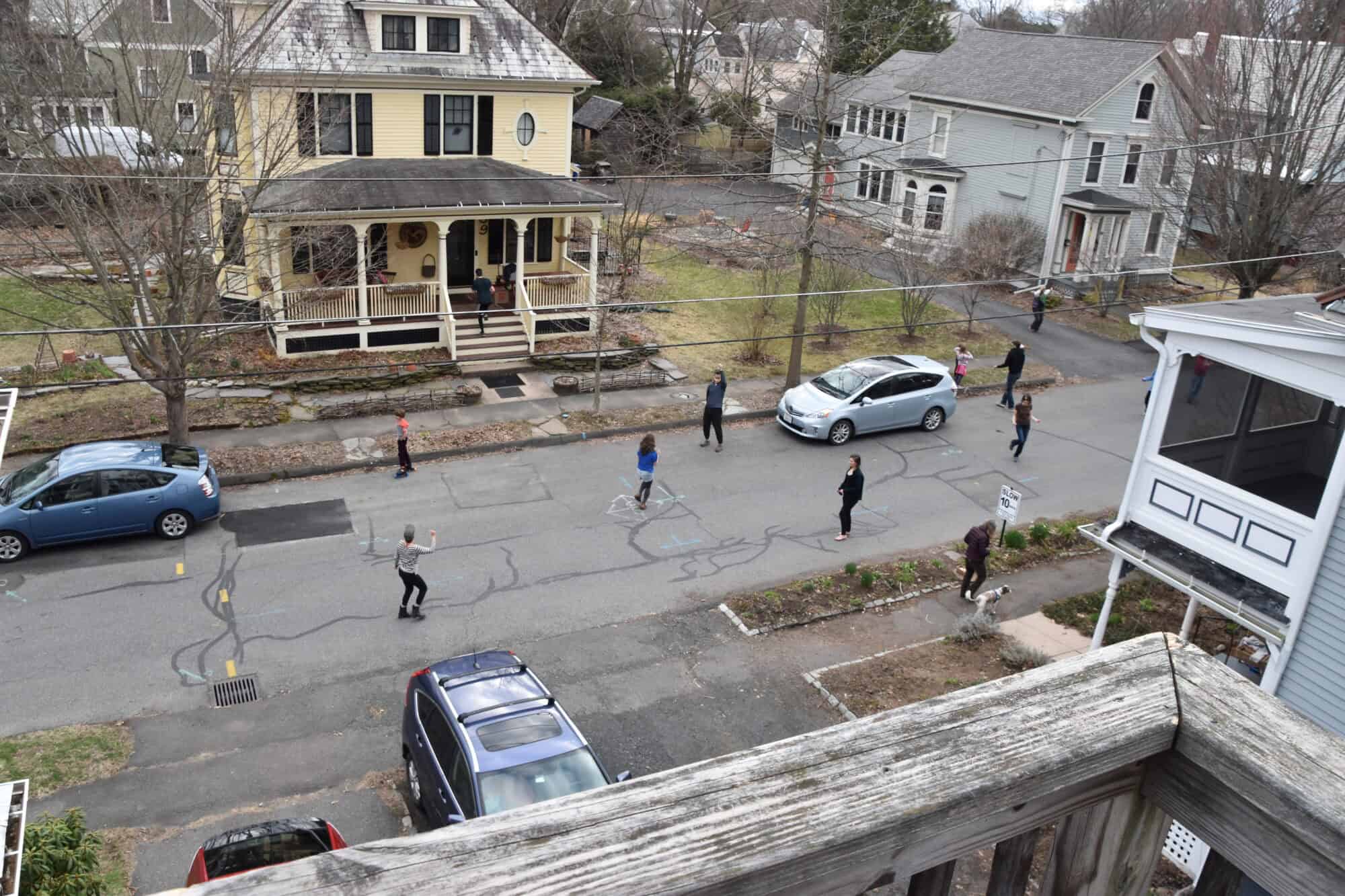 photograph of people dancing on a residential street, taken from a porch above