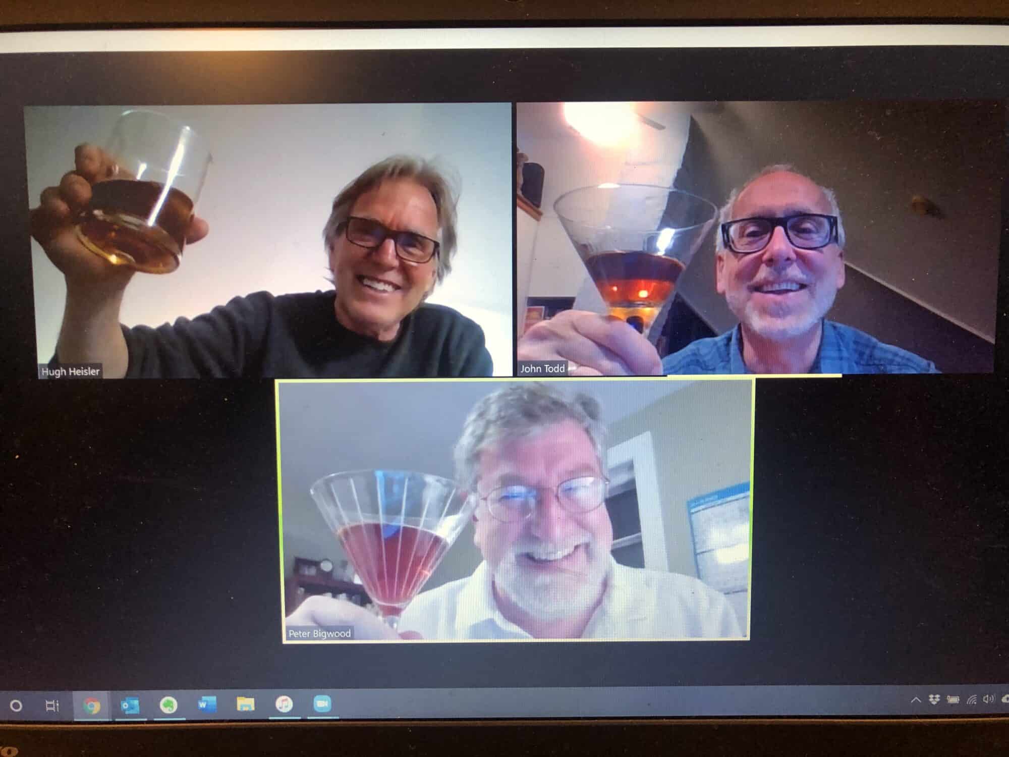 photo of a zoom call on computer monitor, showing three images of people holding up cocktails and smiling