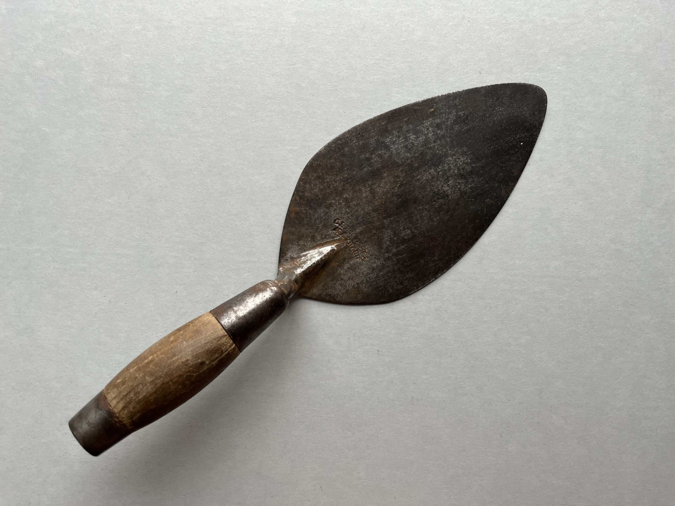 photograph of a metal trowel with a wooden handle