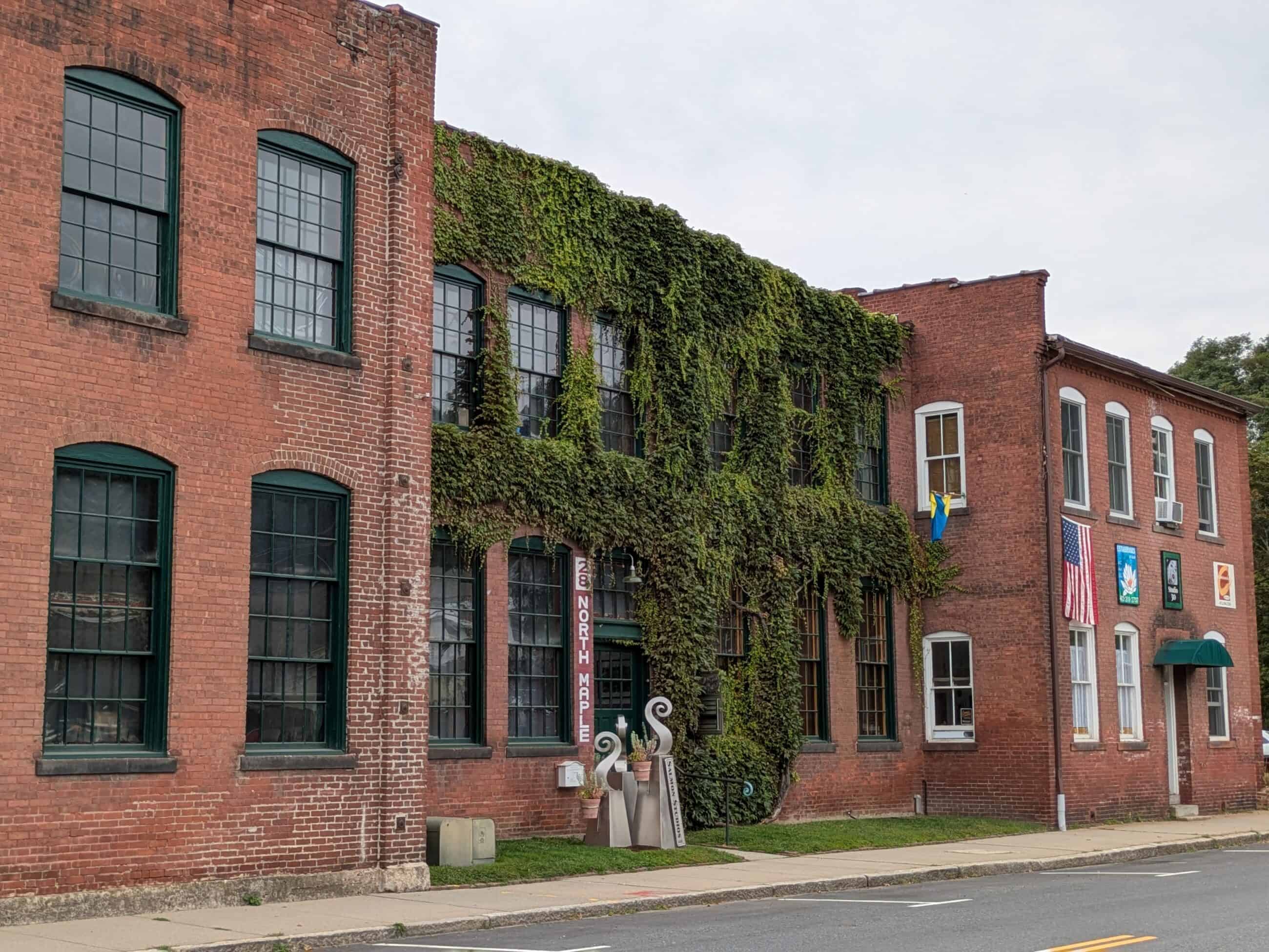 A photograph of the back of the old Norwood Engineering building. The building is red brick and covered in ivy.