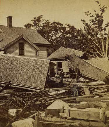old photograph of flood damaged houses and debris strewn around them