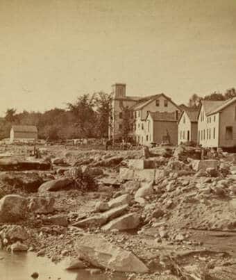 old photograph of houses along a washed out road