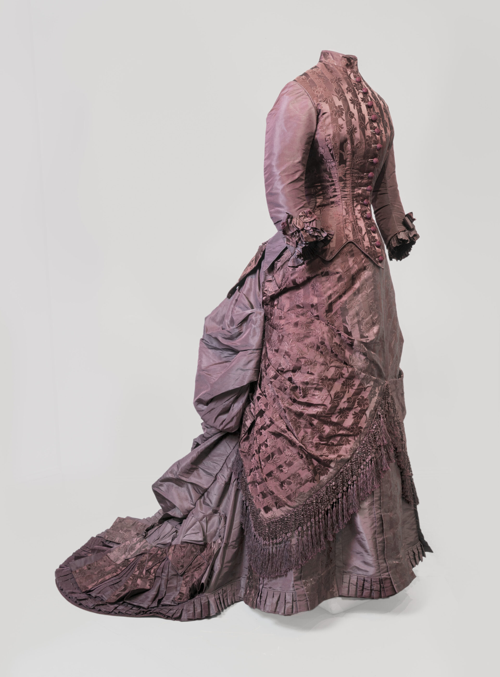 Side profile view of a purple layered dress with buttons.