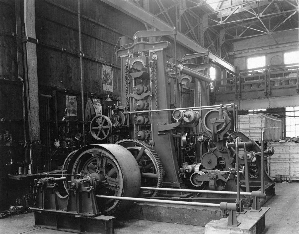 Black-and-white photograph showing machinery in Norwood Engineering Company. The type of machinery is unknown, but many visible gears and wheels.