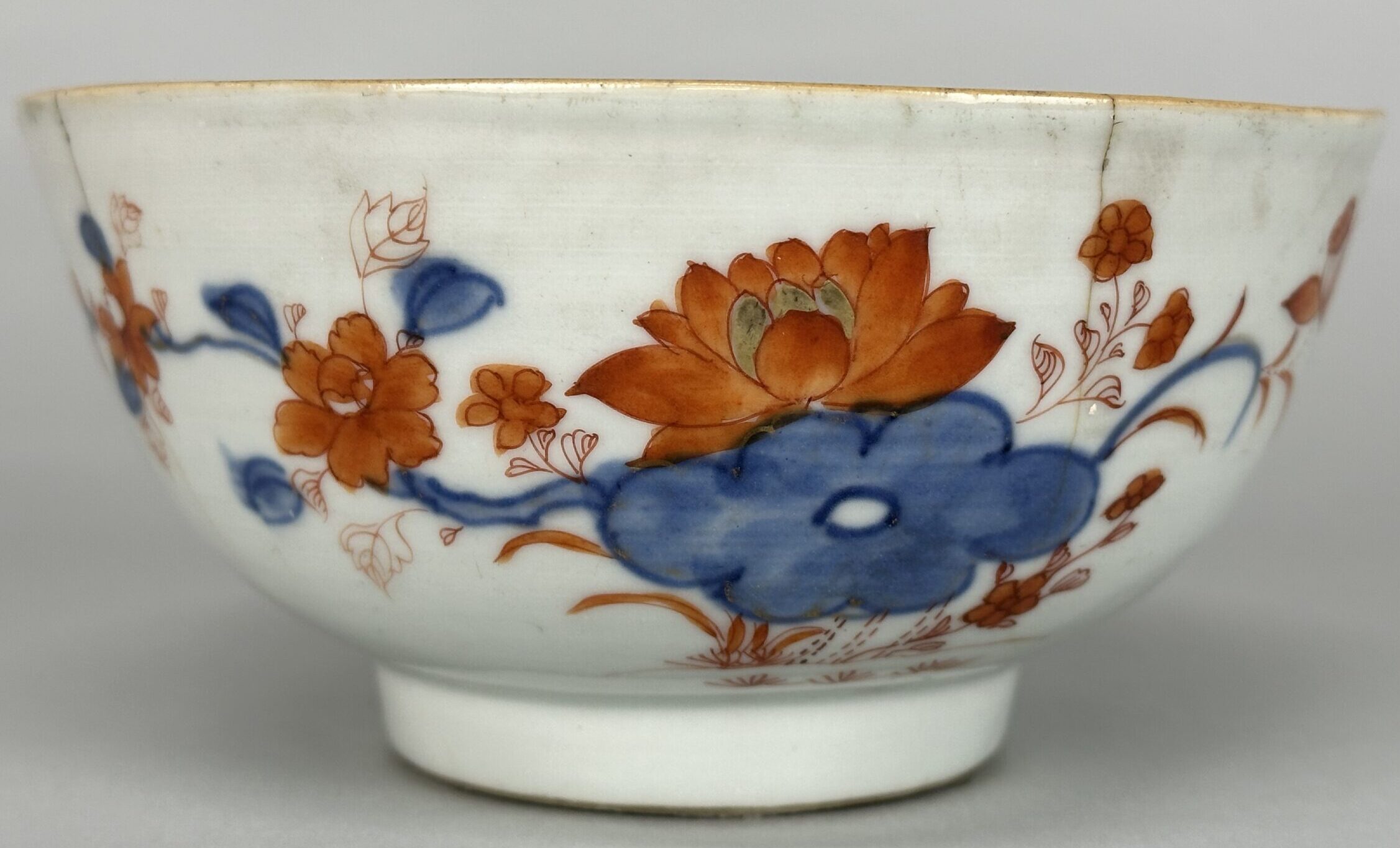 Photograph of a small china bowl owned by Hawley. It has a red and blue simple floral design painted on.