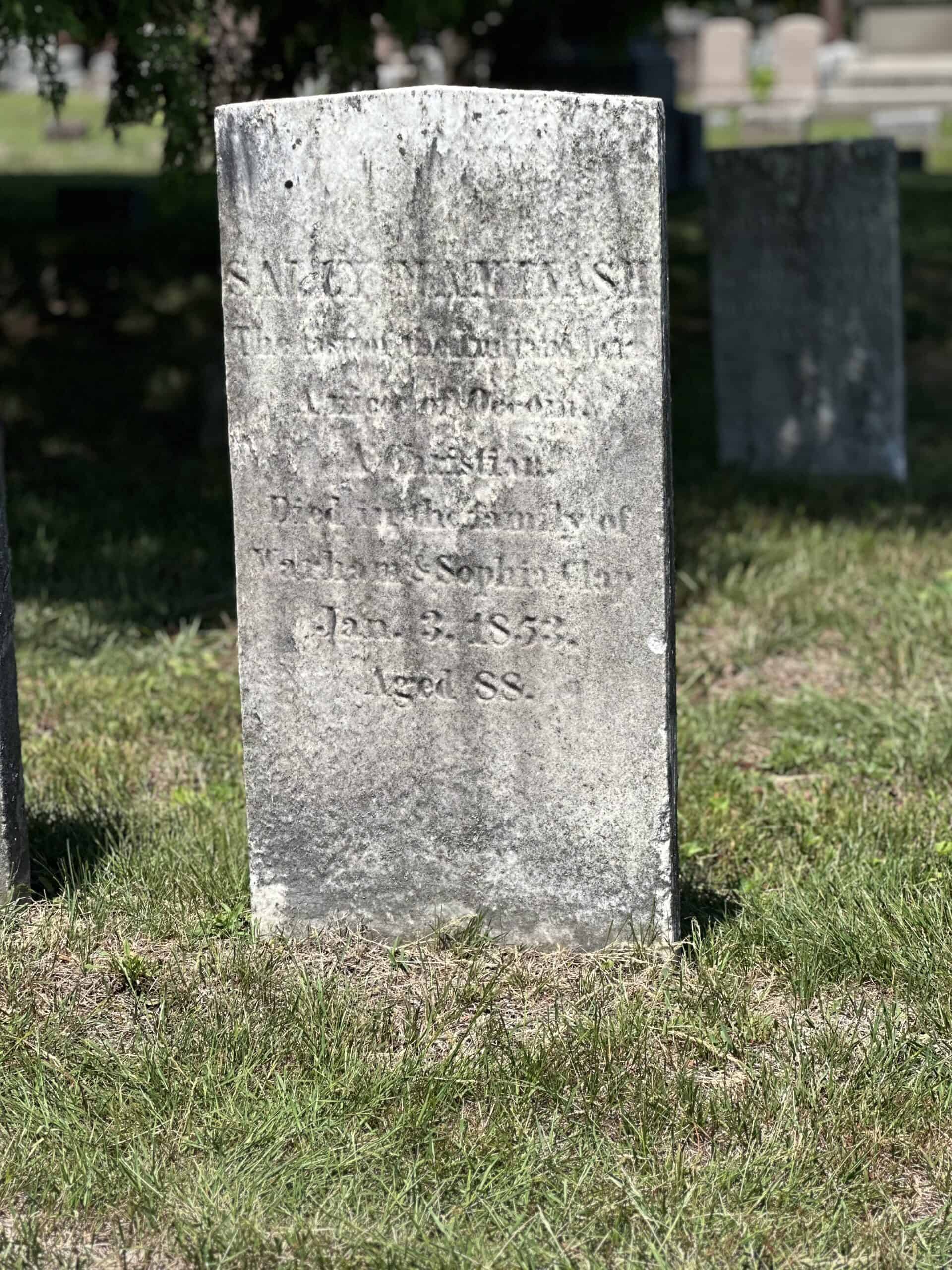 Photograph of Sally Maminash's grave marker. It is very aged, impacting its readability. The engraving reads: "SALLY MAMINASH. The last of the... A Christian. Died... the family of Warham & Sophia Clap Jan. 3, 1853. Aged 88."
