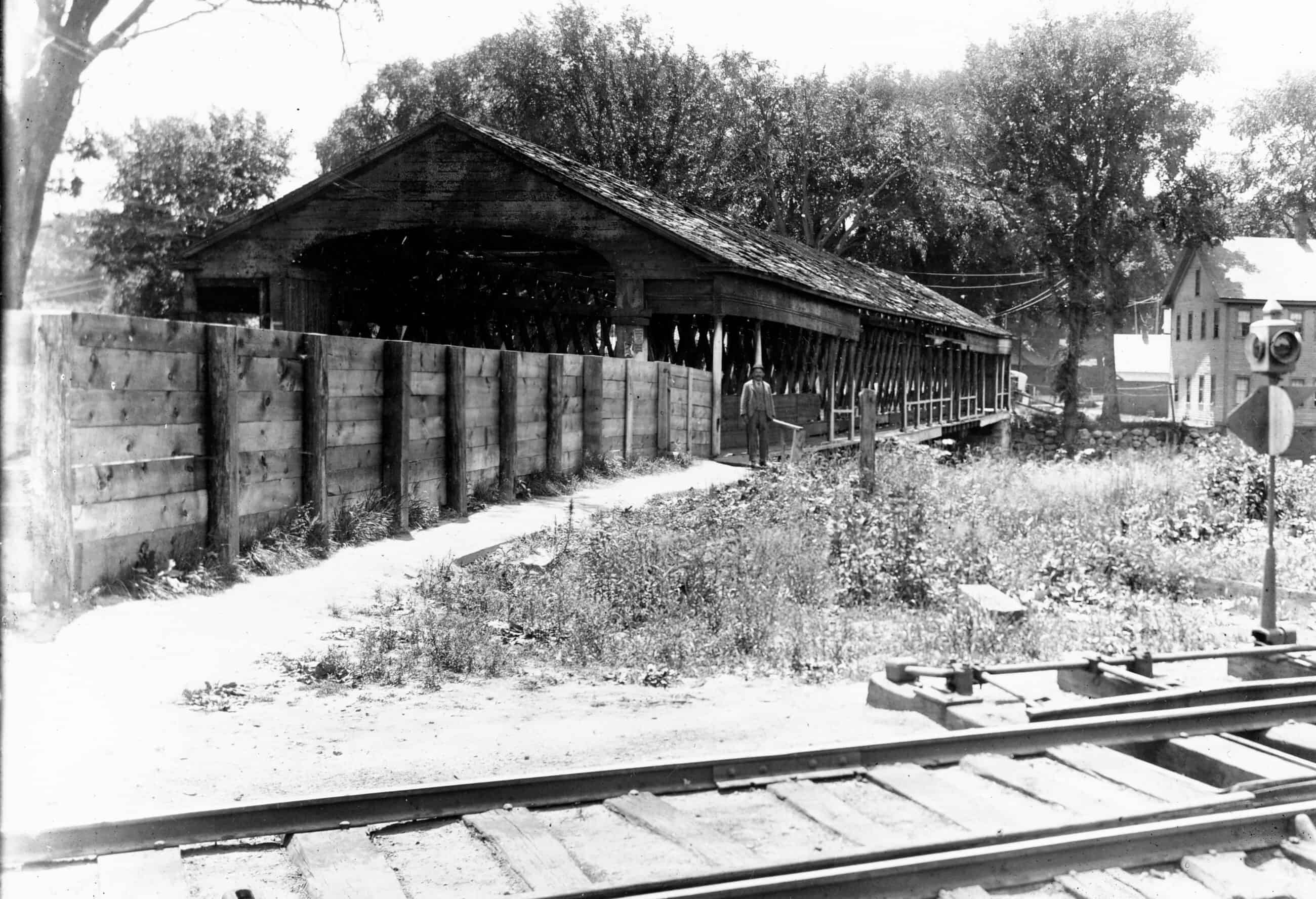 Black-and-white photograph of the Old South Street Bridge alongside the railroad tracks.