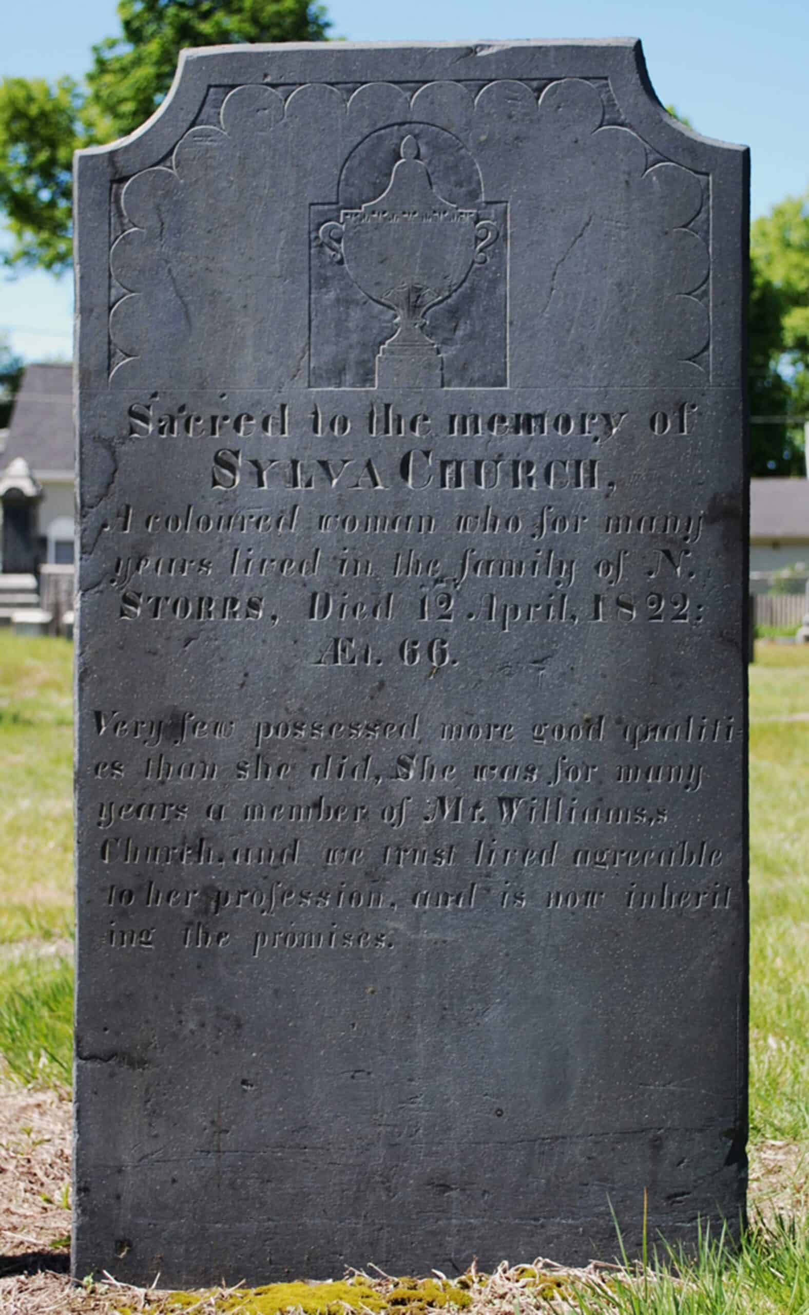 An upright gravestone with scalloped decoration and a central urn at top. Inscription of twelve lines sacred to the memory of Sylva Church who died April 12, 1822.