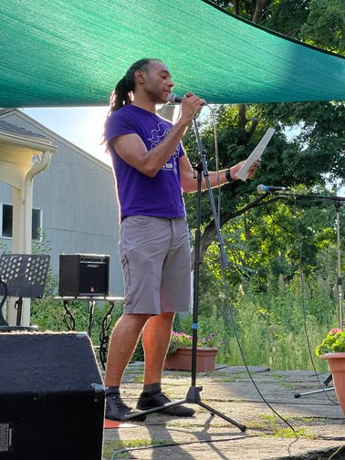 Man speaking into microphone on terrace of Historic Northampton