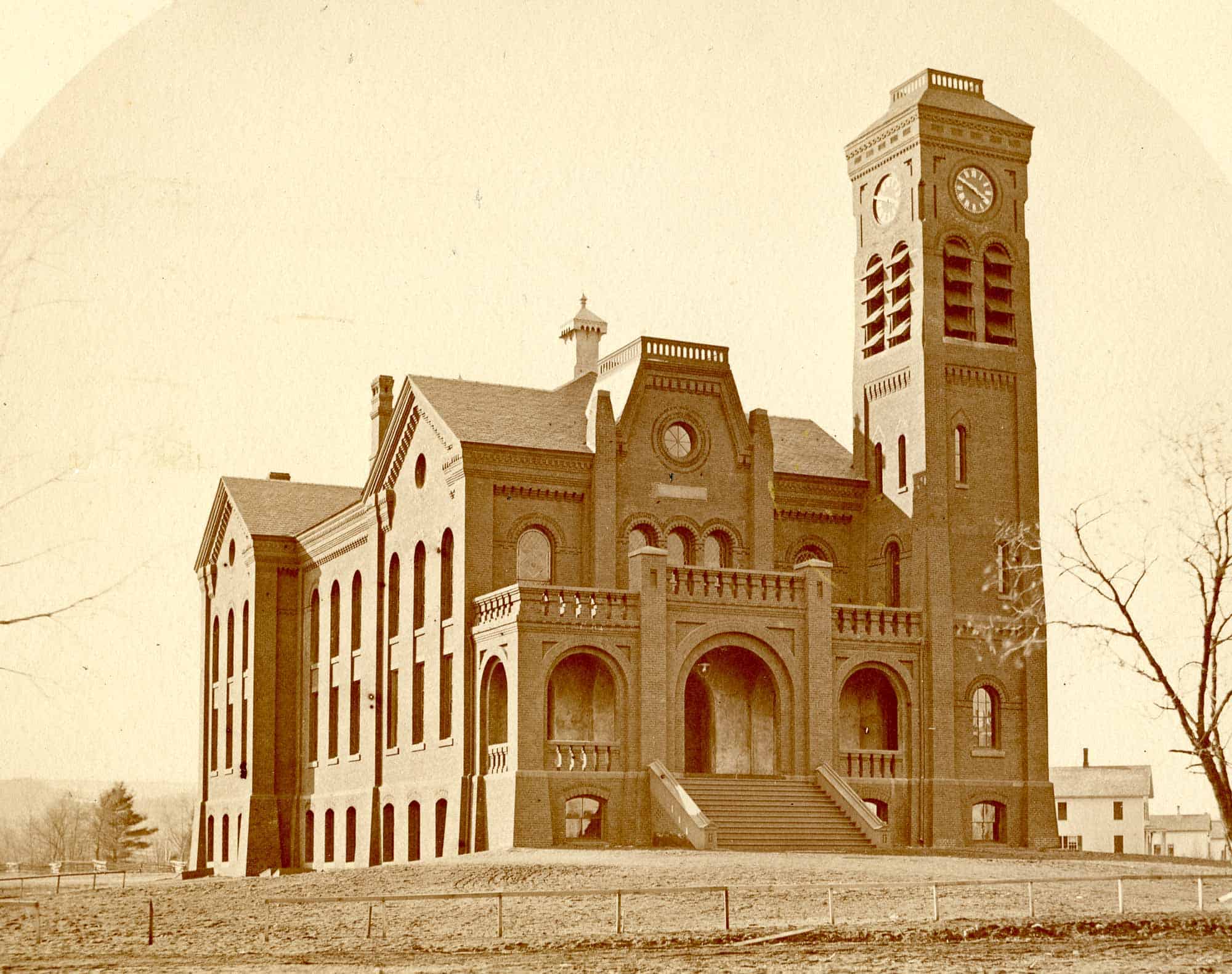 An old photograph of a handsome brick building with Romanesque arches.