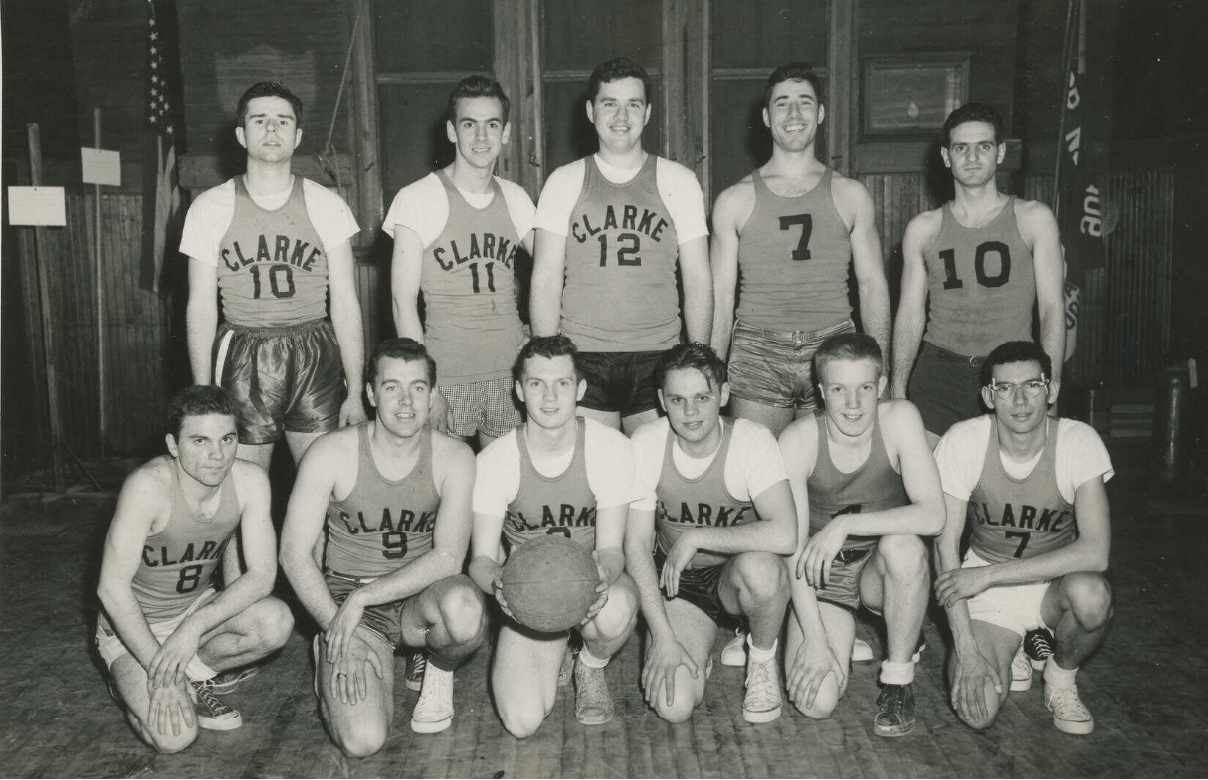 Black-and-white photograph of high school aged boys posing for basketball team photo at Clarke School.