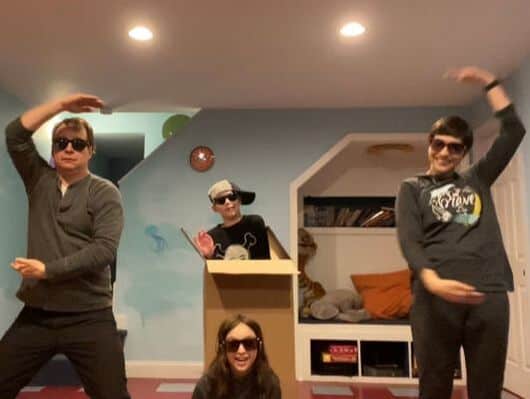Four people posing in dance moves for camera