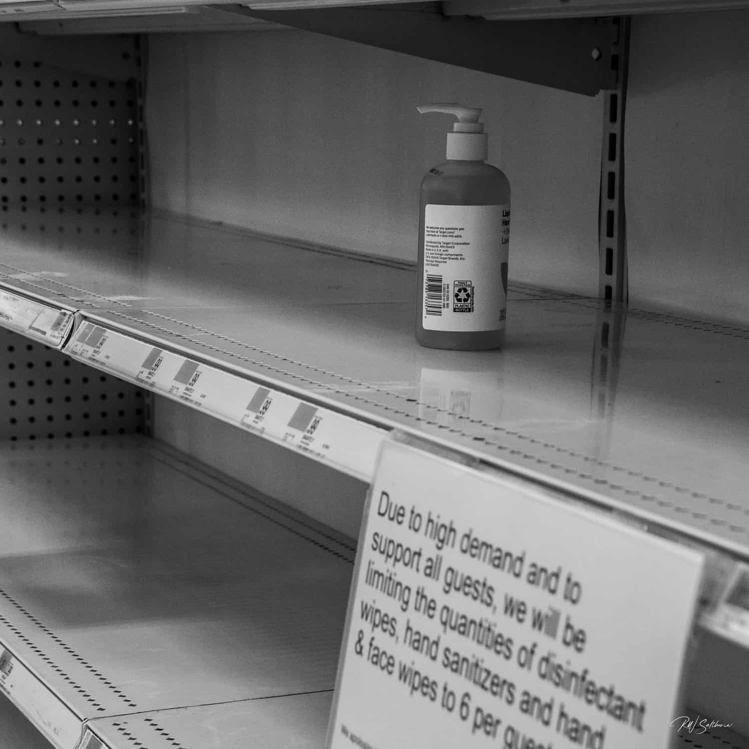 Photo of a single container of hand sanitizer on a bare store shelf