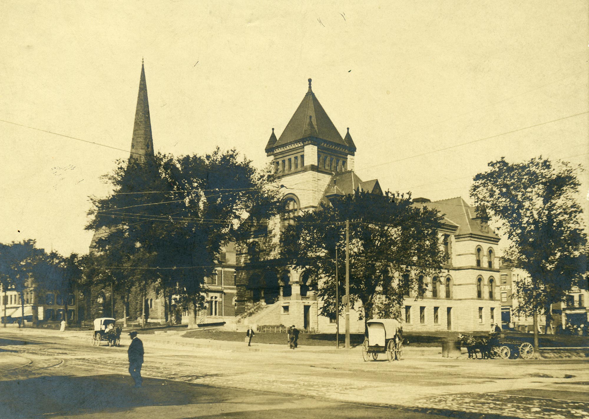 The Northampton Courthouse in 1890??, with horse-drawn carriages and pedestrians.