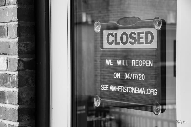 Photo of sign on glass dorr reading CLOSD - We will reopen on 04/17/20 - See AMHERSTCINEMA.ORG