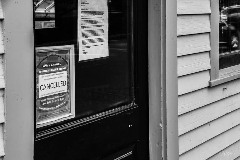 Photo of a door with poster for 49th Annual Spring Flower Show, March 22 and paper over it reading CANCELLED