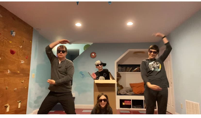 Four people posing in dance moves for camera