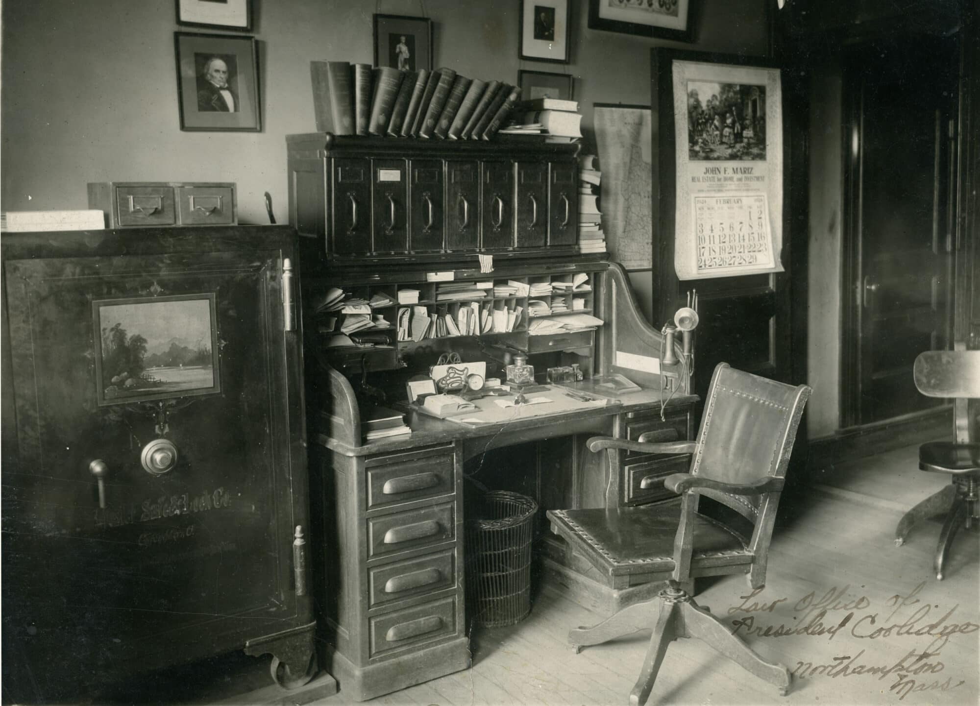 Interior view of the law office of President Calvin Coolidge, with a safe with card files on top; a desk, telephone, chair and waste basket.