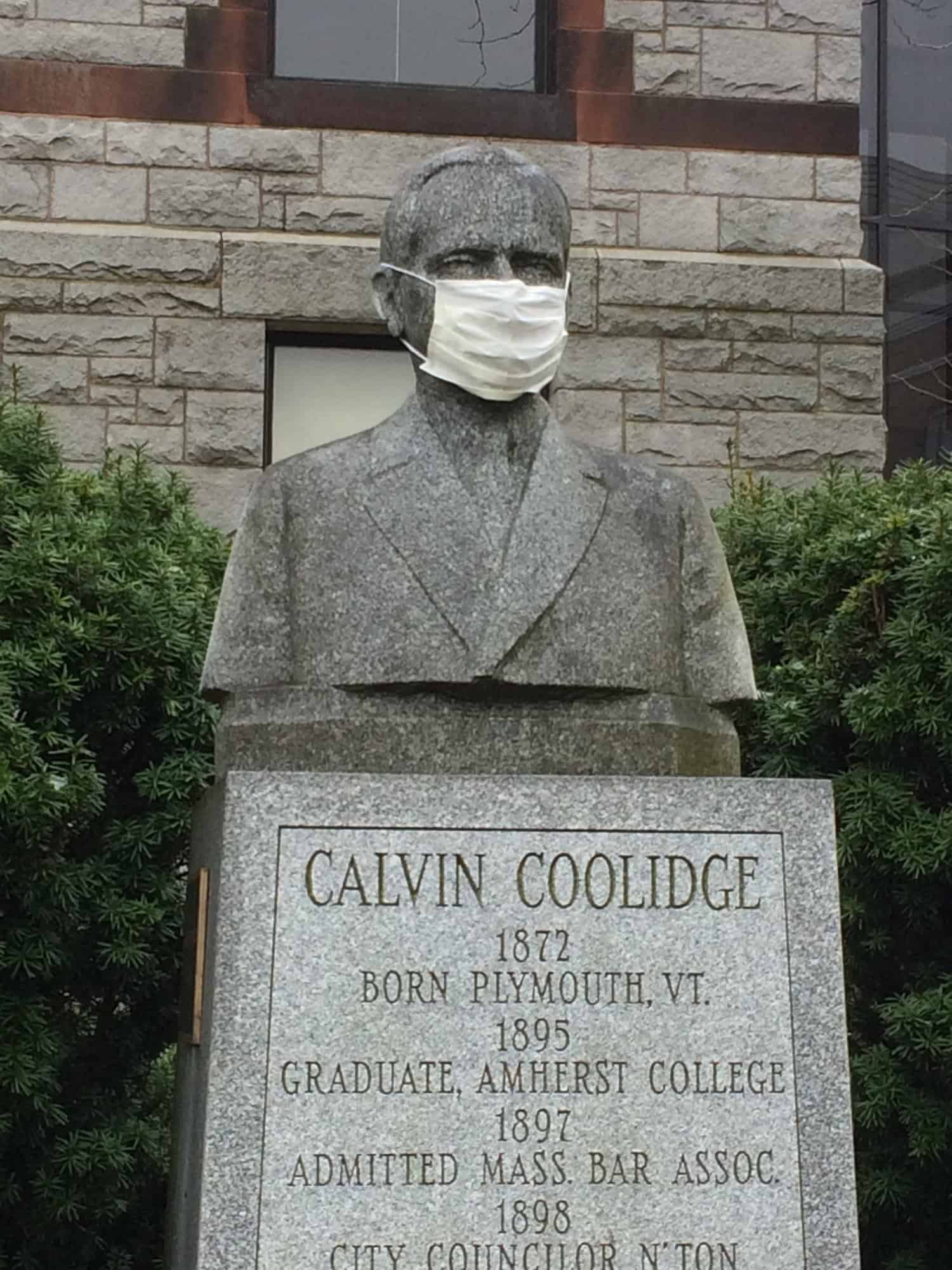 Sculpture of Calvin Coolidge, wearing real cloth surgical mask