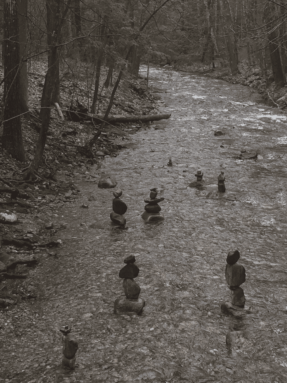 Photo of several small stone towers in a shallow stream