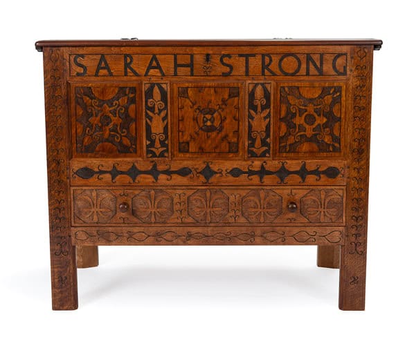 Photograph of the Sarah Strong chest replica. The chest is wooden with designs engraved into it. Toward the top of the chest reads in bold letters: "SARAH STRONG".