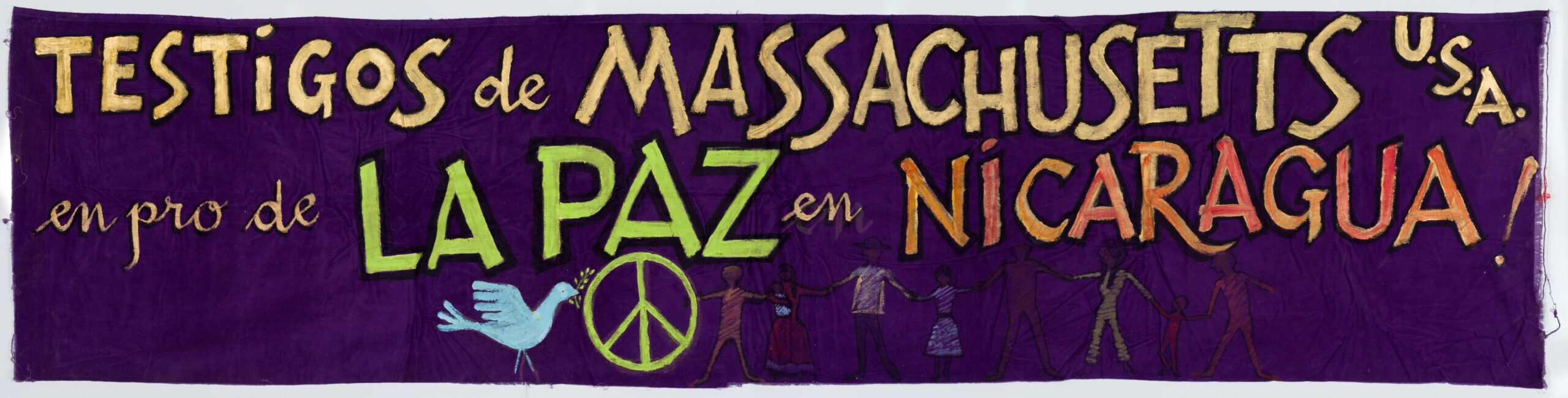 Protest banner in Spanish reading 'Testigos de Massachusetts USA en pro de La Paz en Nicaragua!' There are illustrations of a dove, peace sign and people holding hands along the bottom.
