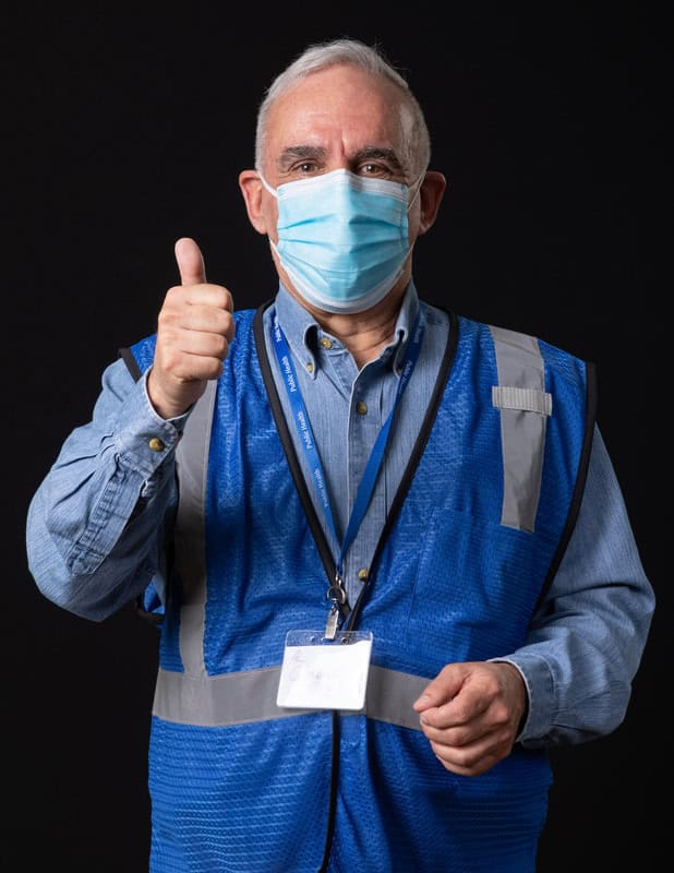 Photo of person wearing face mask and blue vest