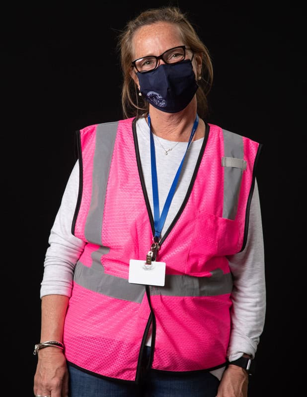 photo of person wearing face mask and pink vest