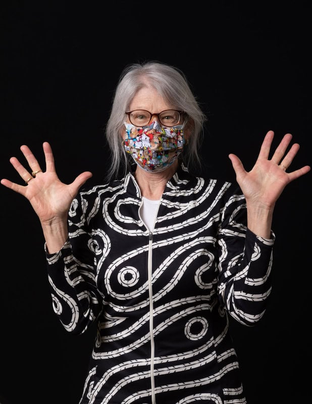 photo of person wearing face mask and holding up both hands