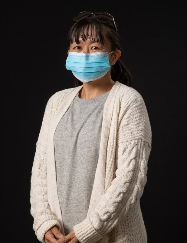 Photo of person wearing face mask and white cardigan