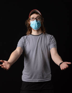 photo of person wearing face mask and a t-shirt, holding out both arms