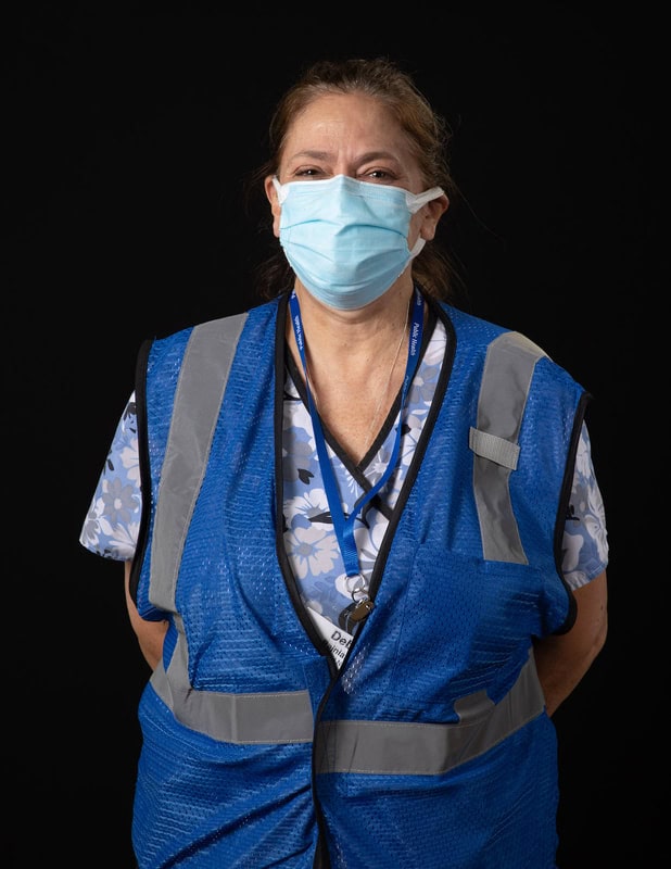 photo of person wearing face mask and a bright blue vest