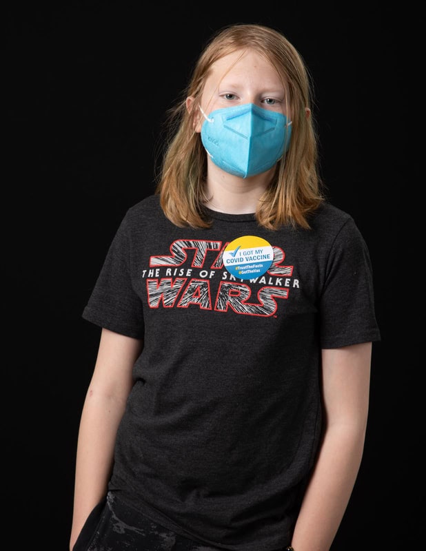 photo of young person wearing face mask and tStar Wars t-shirt with 'I got my covid vaccine' sticker