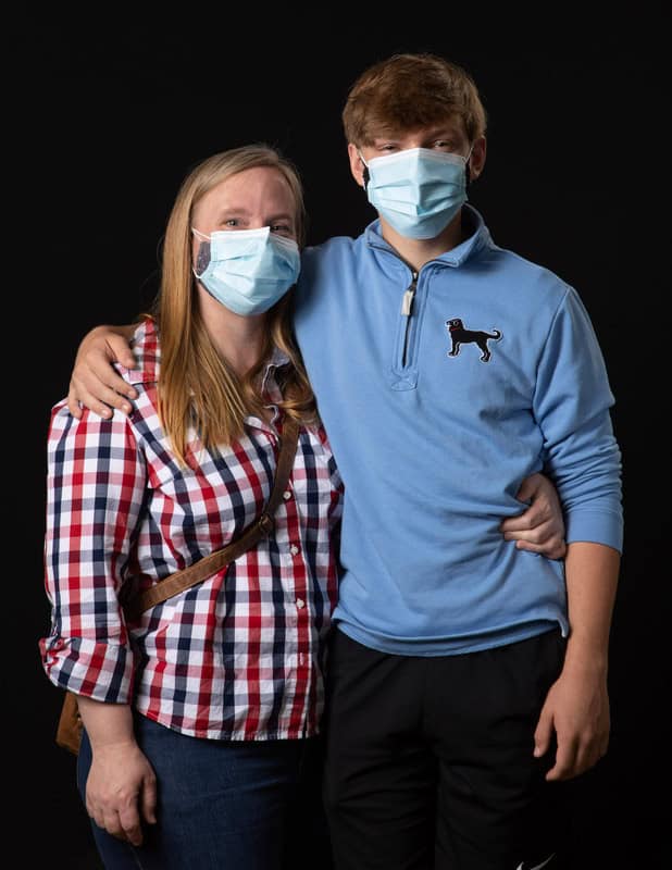 photo of two people with arms around each other wearing face masks