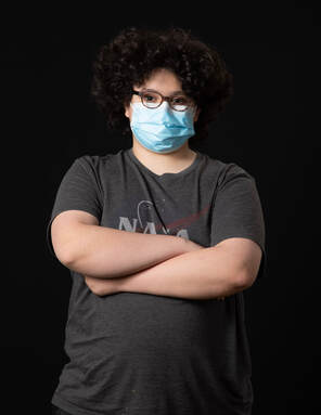 photo of young person wearing face mask with arms crossed