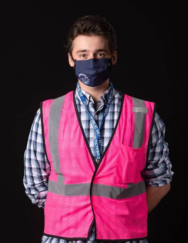 photo of person wearing face mask and pink vest