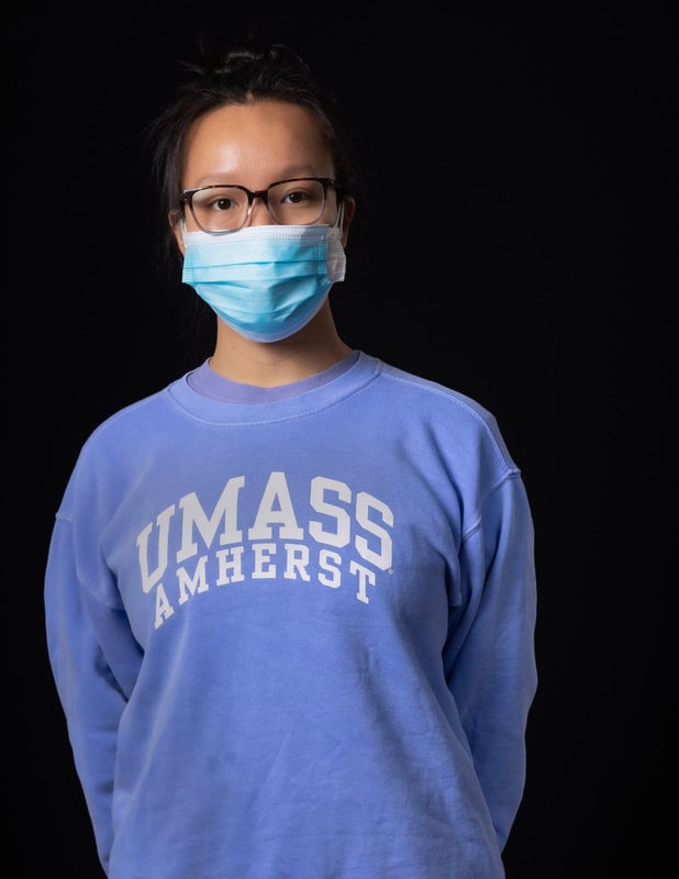 Photo of person wearing face mask and blue UMass Amherst sweatshirt