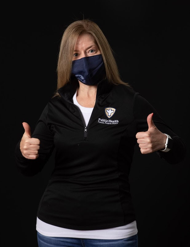 photo of person in face mask and black sweatshirt reading 'Public Health' with two thumbs up