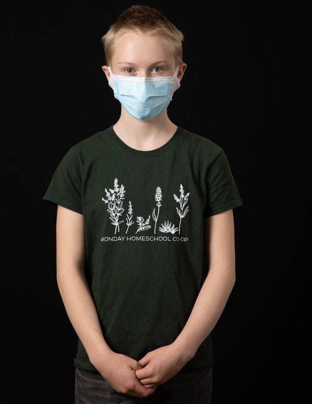 photo of young person wearing face mask and green illustrated tshirt