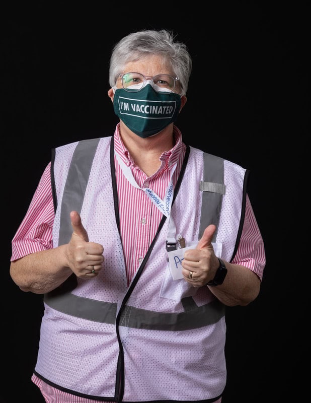 Photo of person wearing face mask and light pink vest