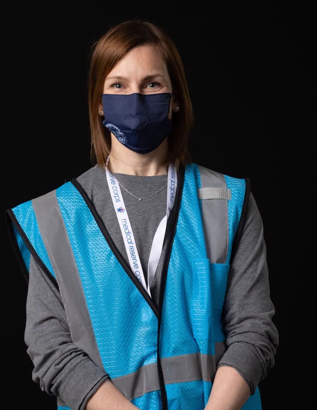 Photo of person wearing face mask and light blue vest