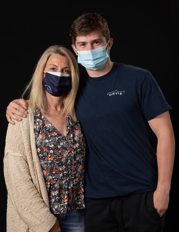photo of two people with arems around each other wearing face masks