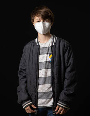 photo of young person wearing face mask and black jacket