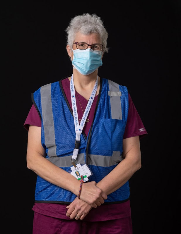 Photo of person wearing face mask and blue vest