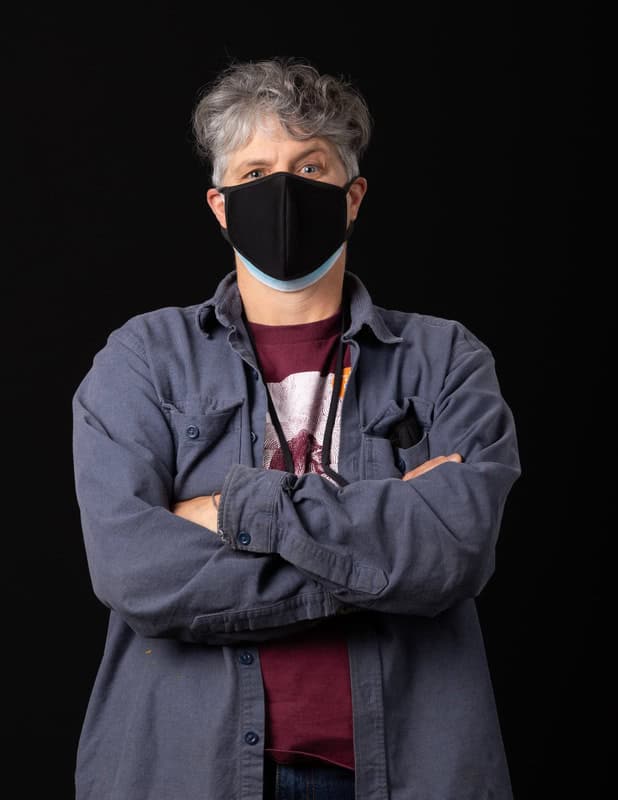 photo of person wearing face mask with arms folded across chest